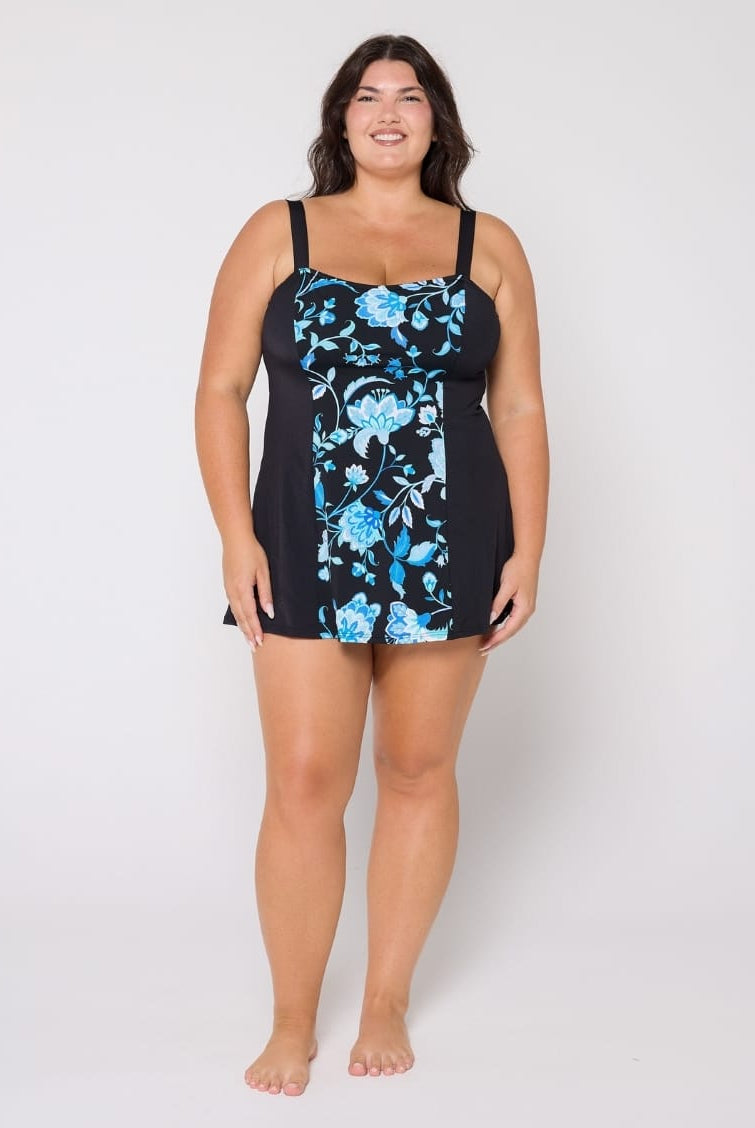 Woman wearing a black swimsuit with blue floral pattern on a white background
