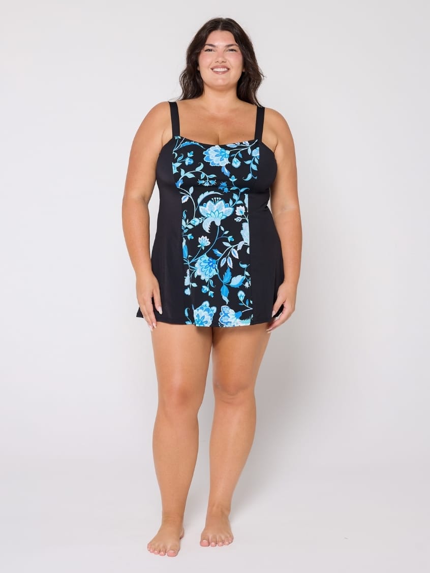 Woman wearing a black swimsuit with blue floral pattern on a white background