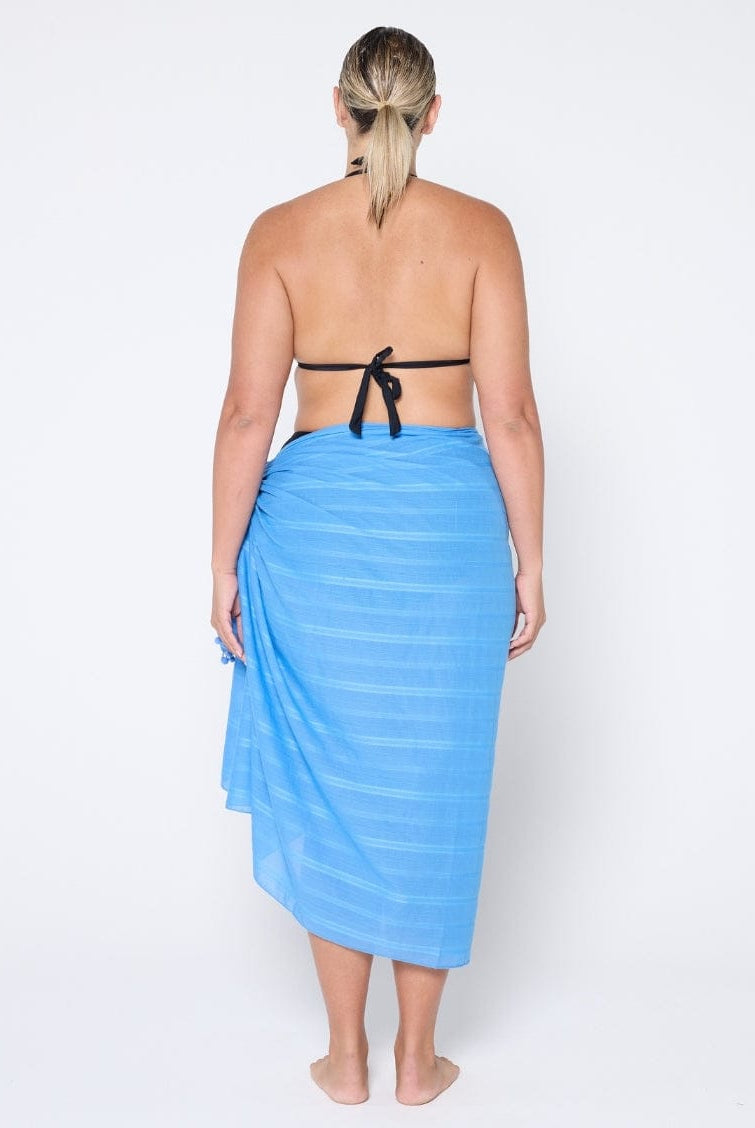 Woman wearing a blue striped sarong on a white background