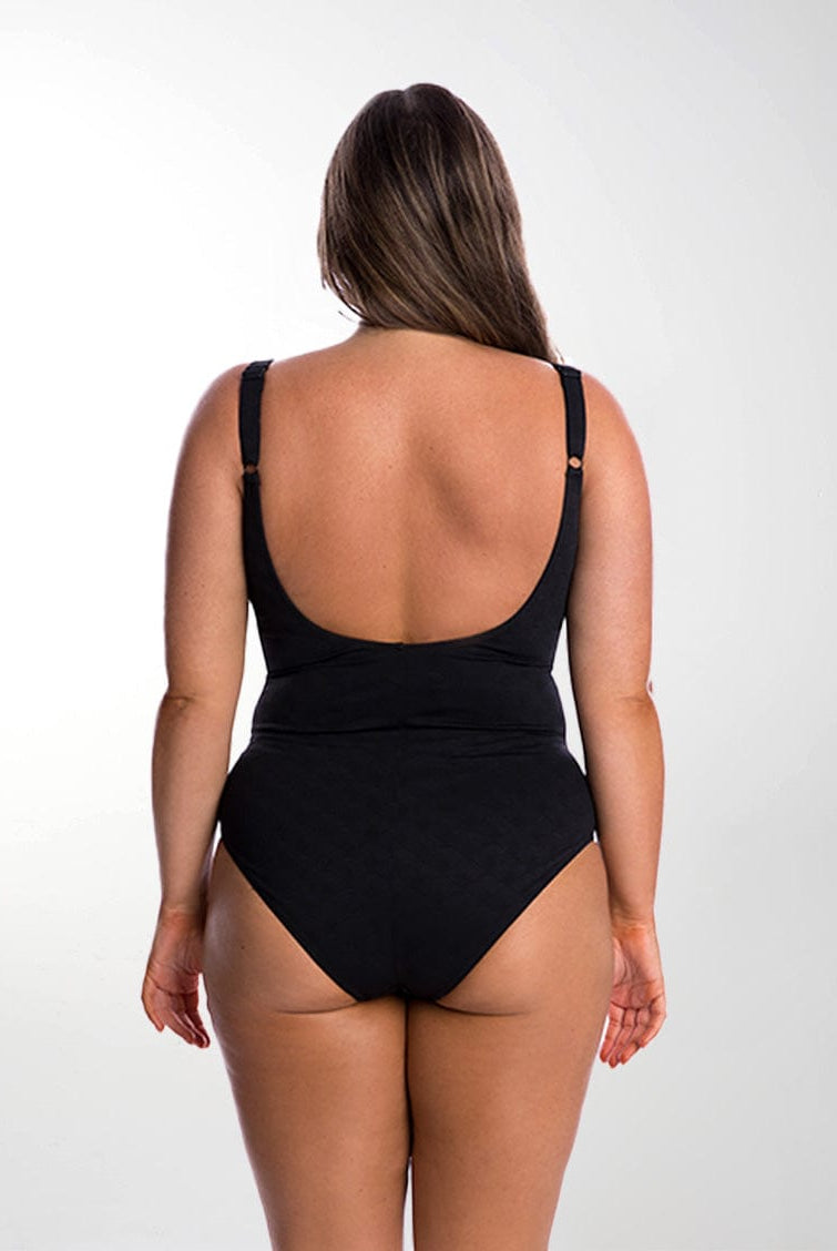 Brunette model in studio wearing scoop back one piece with adjustable straps