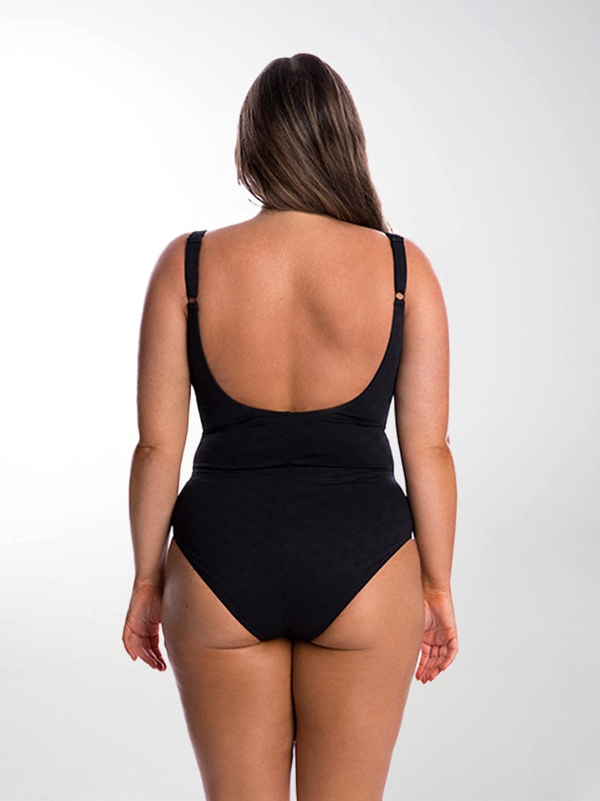 Brunette model in studio wearing scoop back one piece with adjustable straps