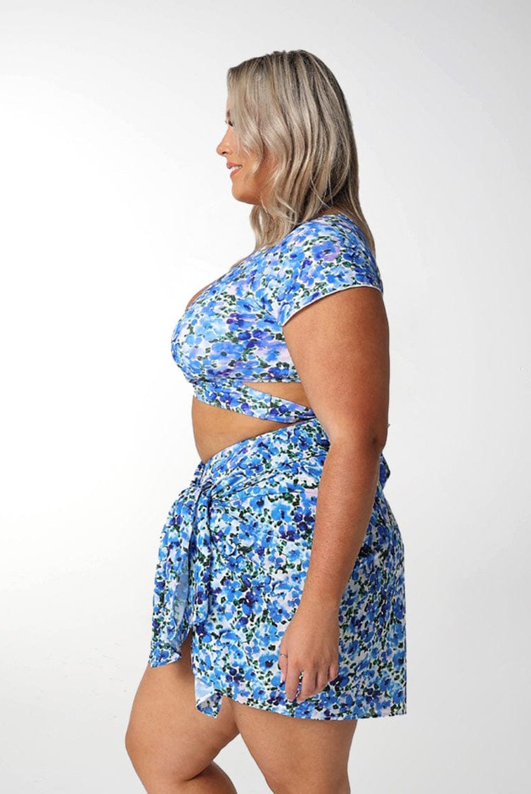Model wearing blue floral short sarong with matching bikini set
