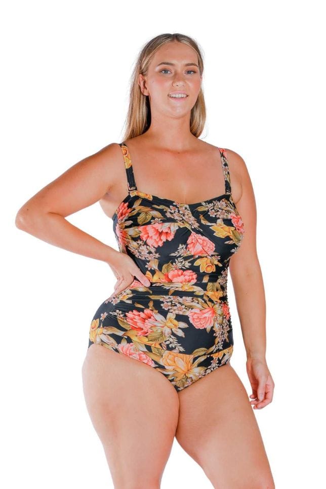Model wearing orange and yellow floral and black printed twist front bandeau one piece