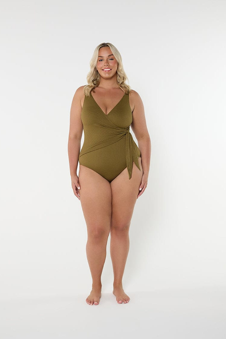 Woman wearing a green swimsuit on a white background