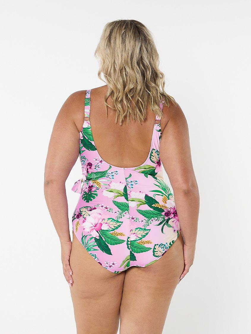 Blonde model facing back in studio wearing multicoloured floral one piece with scoop back and adjsutable straps