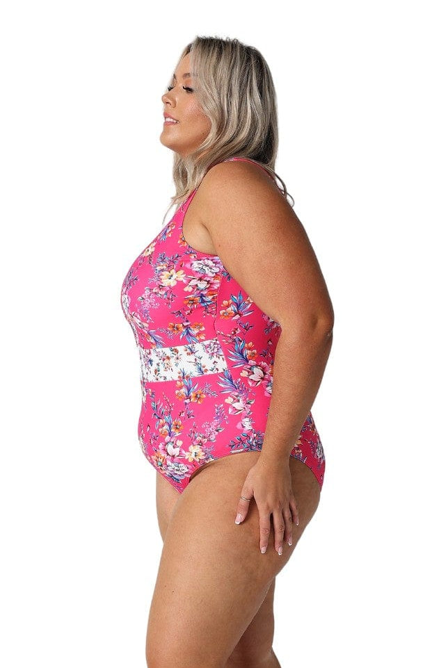 Model showing side of hot pink floral sleeveless swimsuit