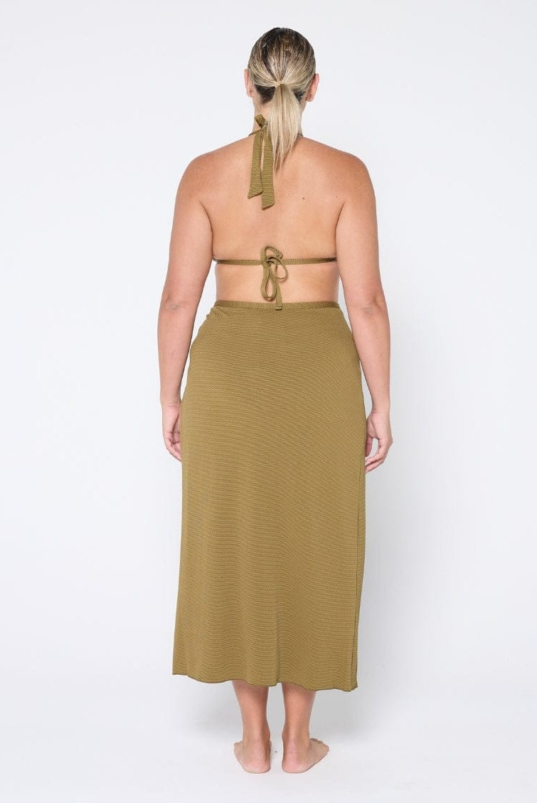 Woman wearing a green halter top and skirt set on a white background