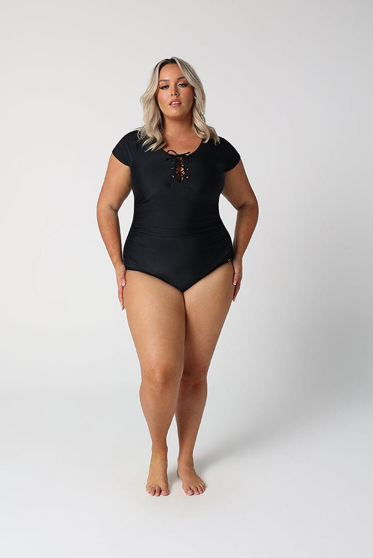 Woman wearing a black swimsuit on a white background