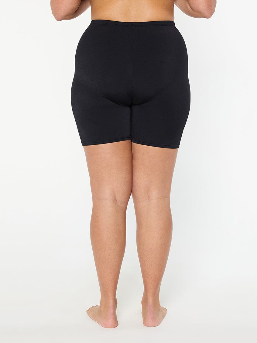 Person wearing black shorts on a white background
