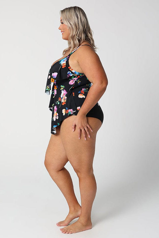 Woman wearing a black floral swimsuit on a white background