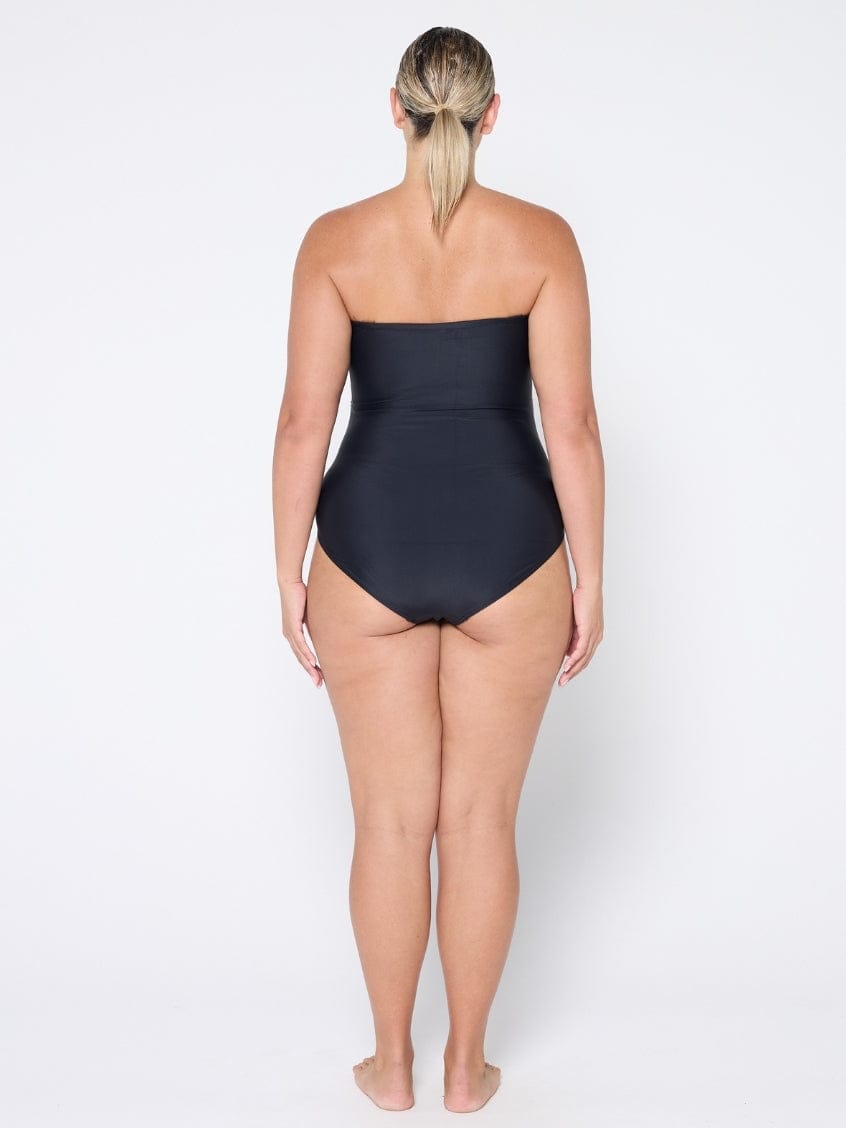 Person wearing a black strapless swimsuit on a white background