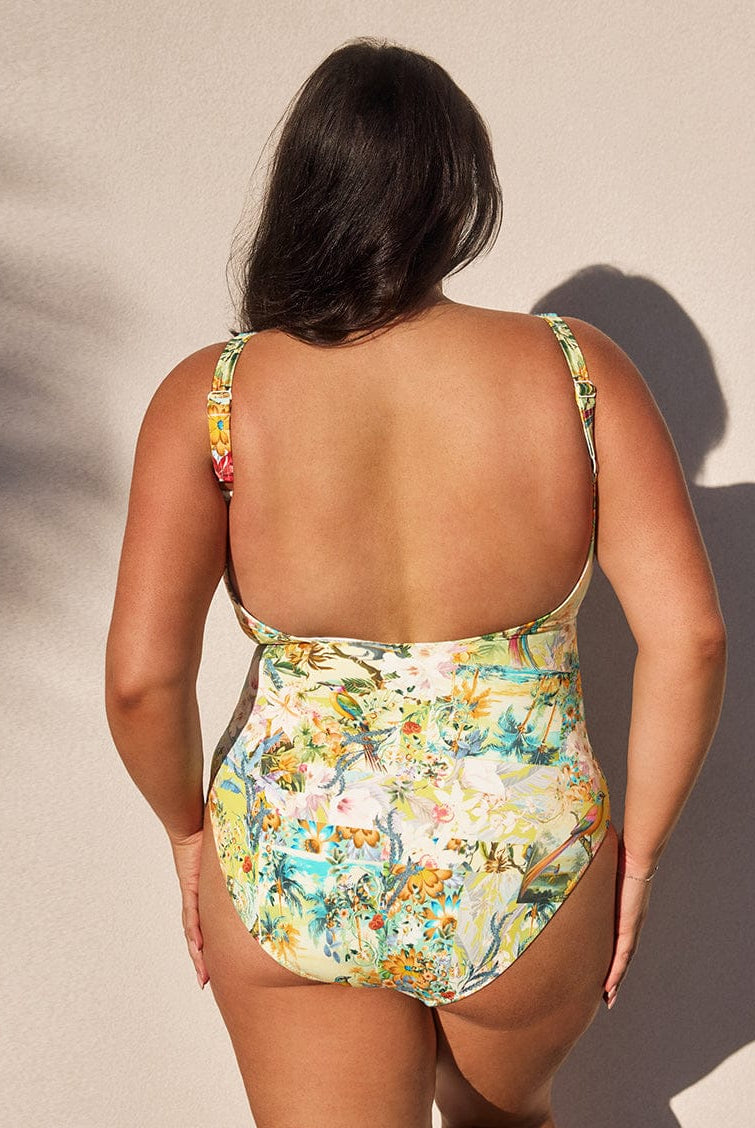 Woman wearing a floral swimsuit against a neutral background