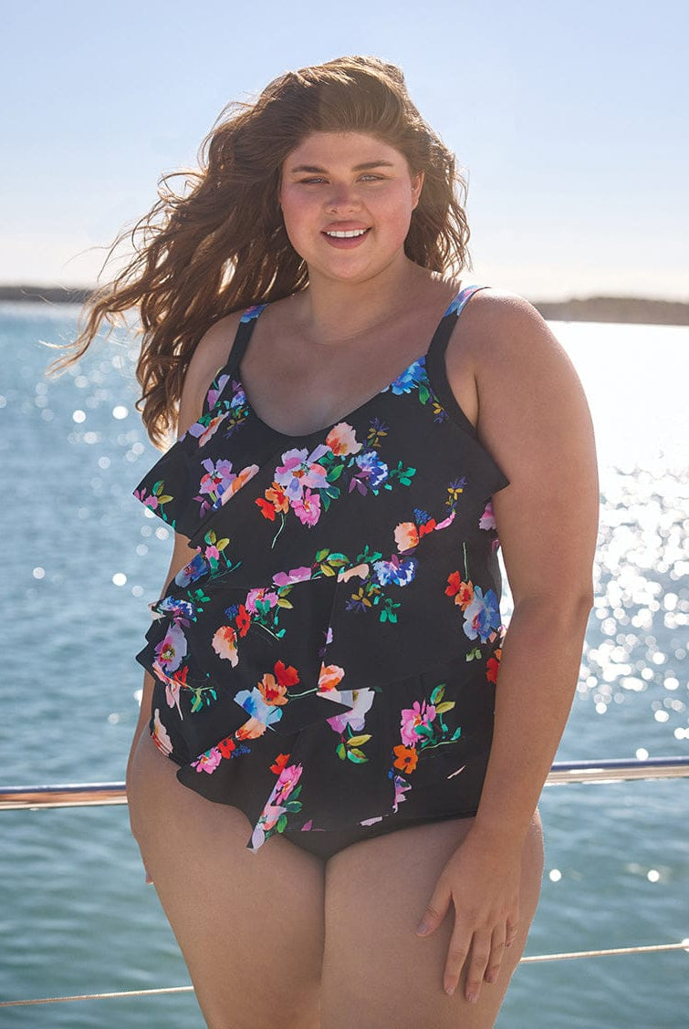 Woman wearing a floral swimsuit by the water