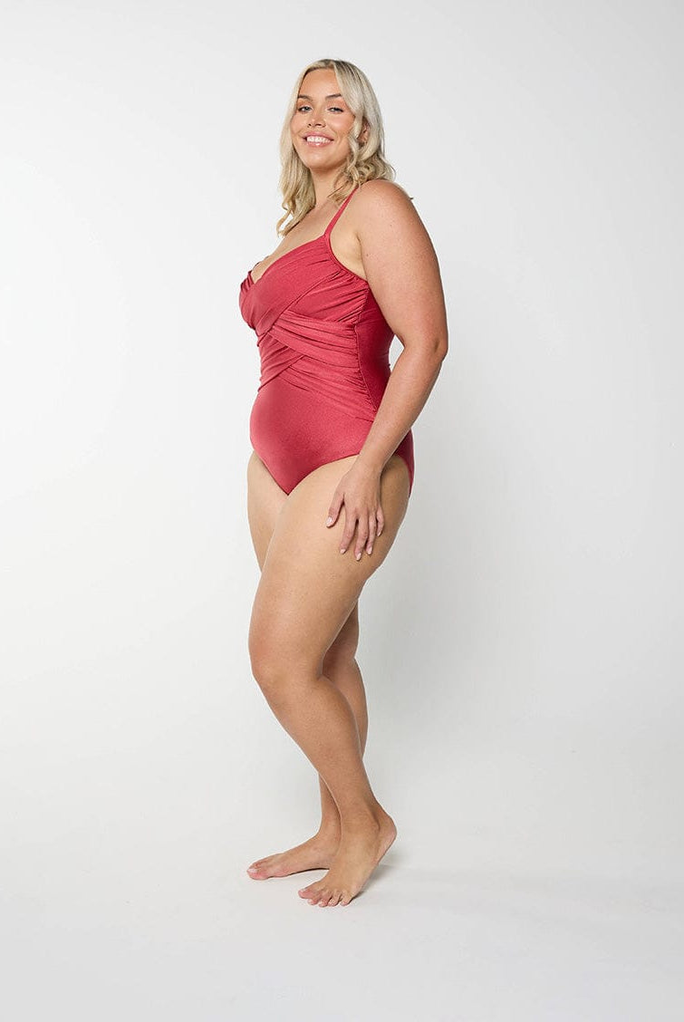 Blonde model in studio wearing a metallic red one piece with adjustble straps and ruching