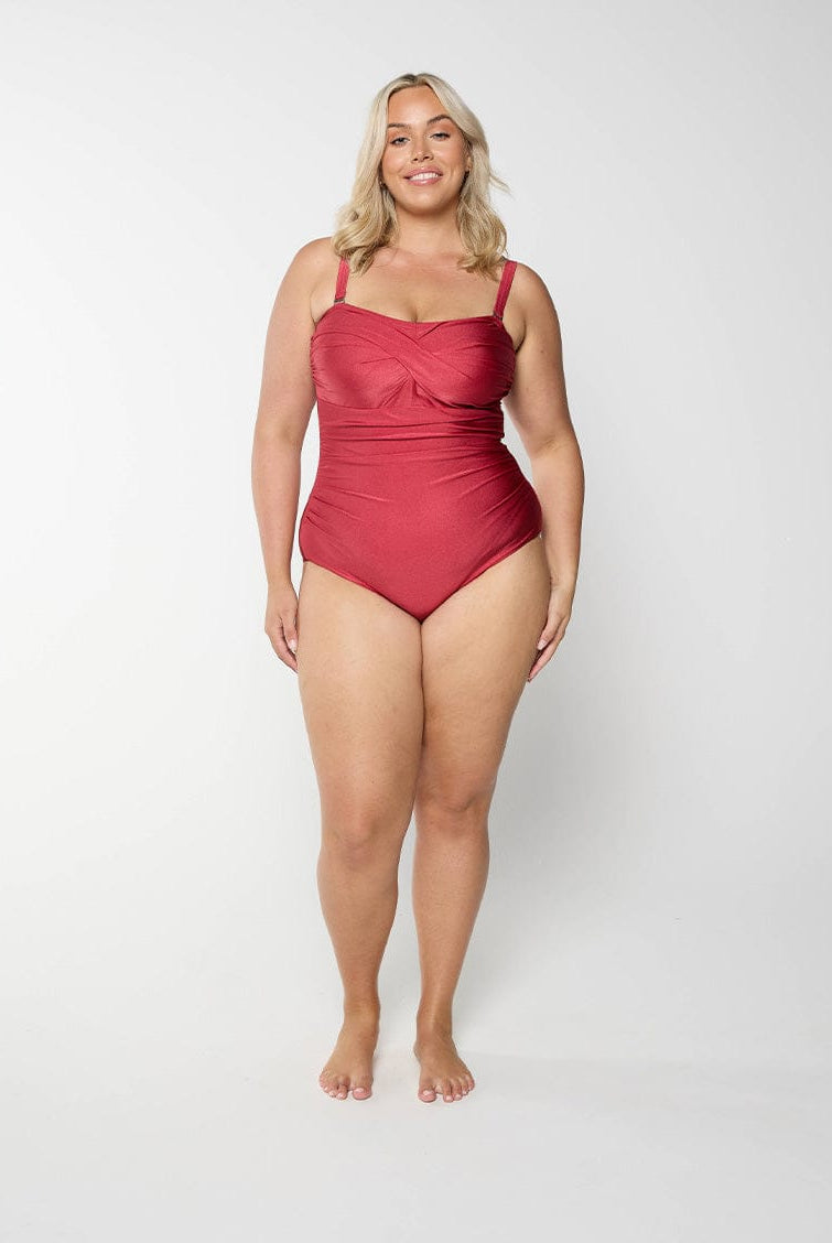 Woman wearing a metallic red swimsuit on a white background