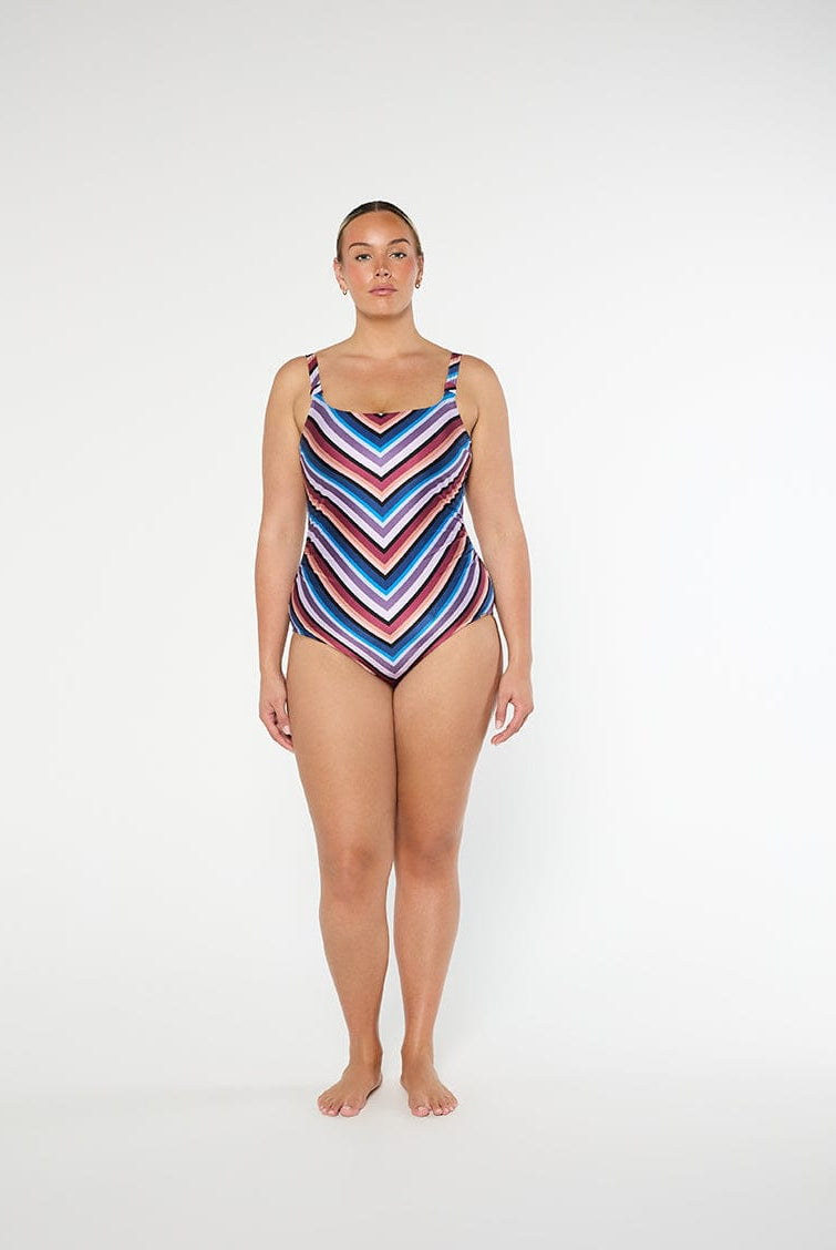 Woman wearing a colorful striped swimsuit on a white background