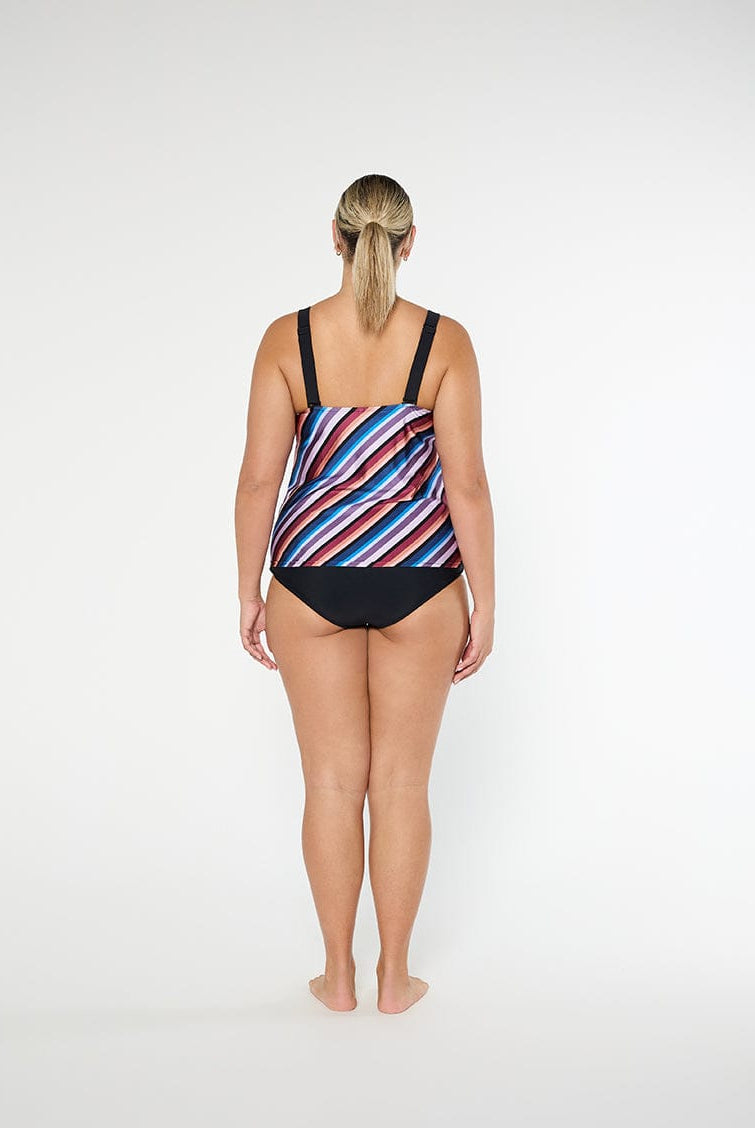 Woman wearing a colorful striped swimsuit on a white background