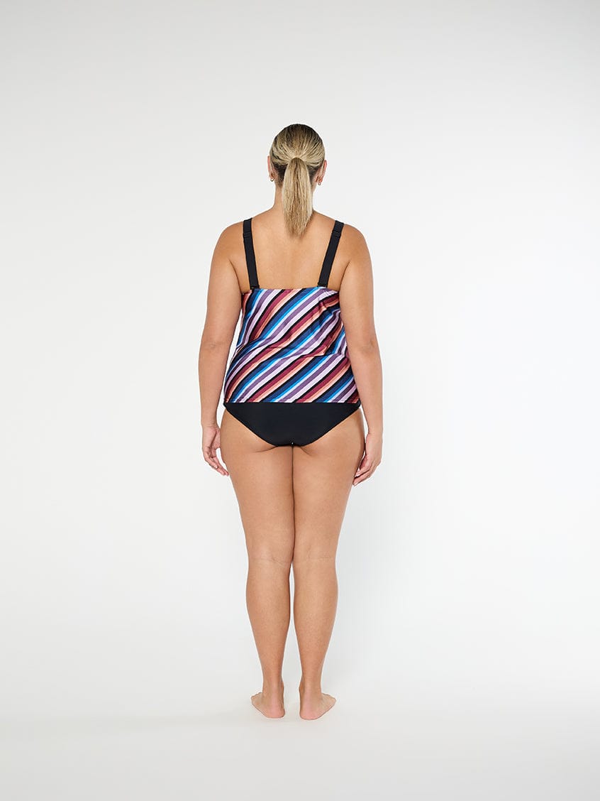 Woman wearing a colorful striped swimsuit on a white background
