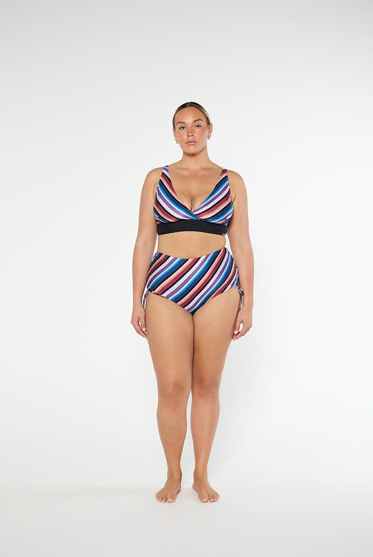 Woman wearing a colorful striped swimsuit on a white background