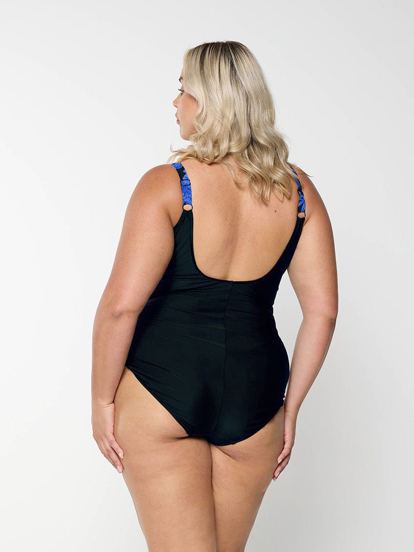 model showing back of blue and black floral women's swimsuit
