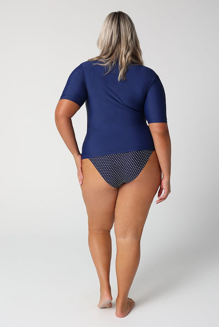 Person wearing a blue swimsuit with a patterned bottom section on a white background