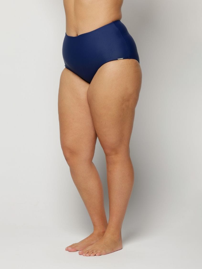 a woman wearing a Navy blue high-waisted swimsuit on a plain background