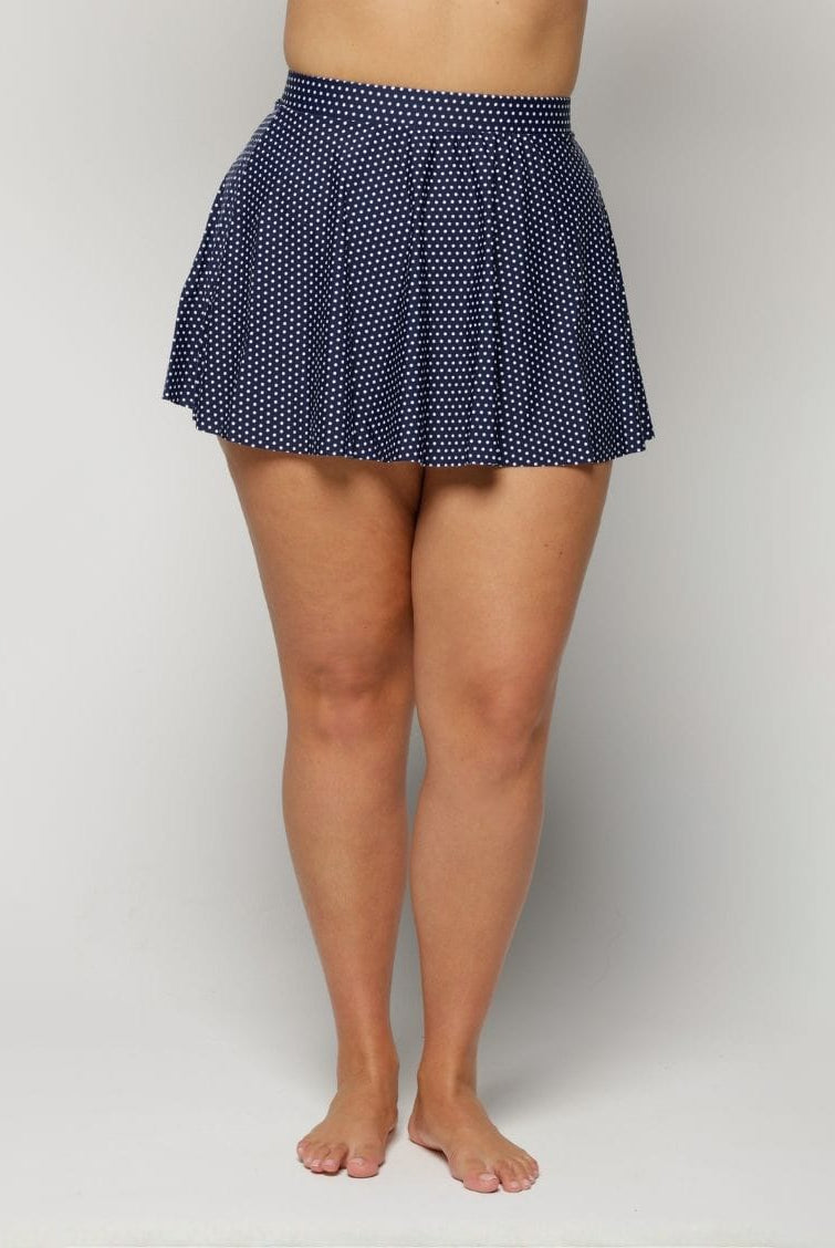 Navy polka dot skirt worn by a woman on a white background