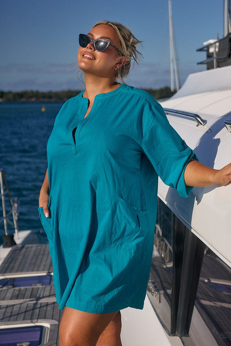 Blonde model wearing teal cotton over shirt on boat