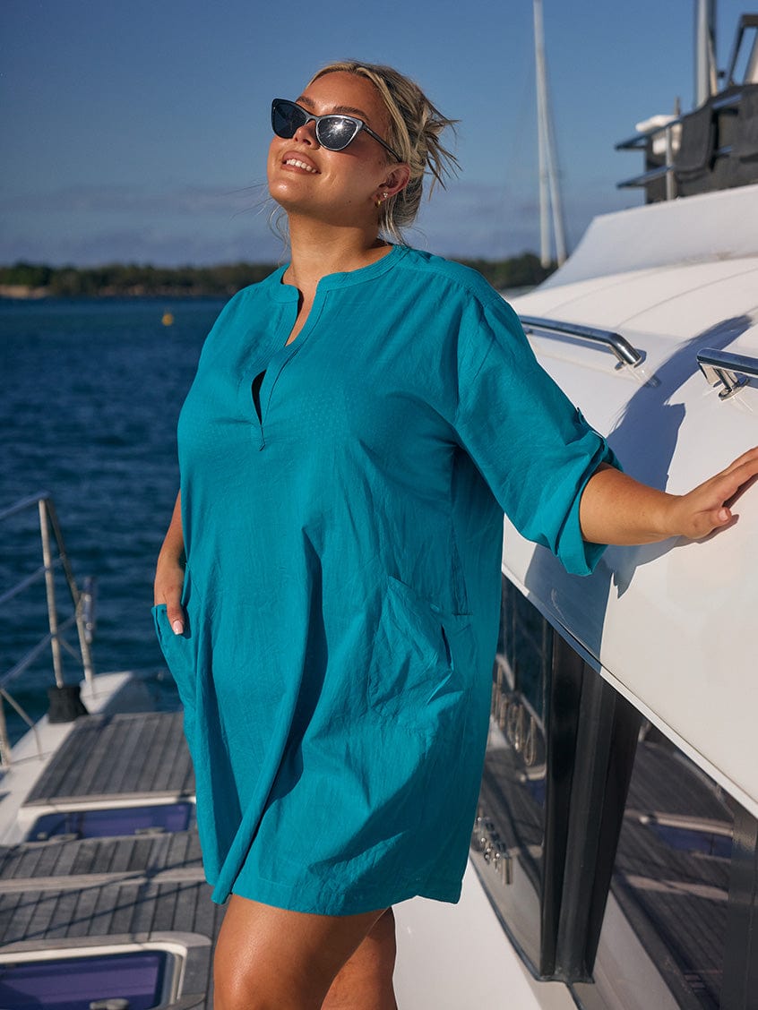 Blonde model wearing teal cotton over shirt on boat