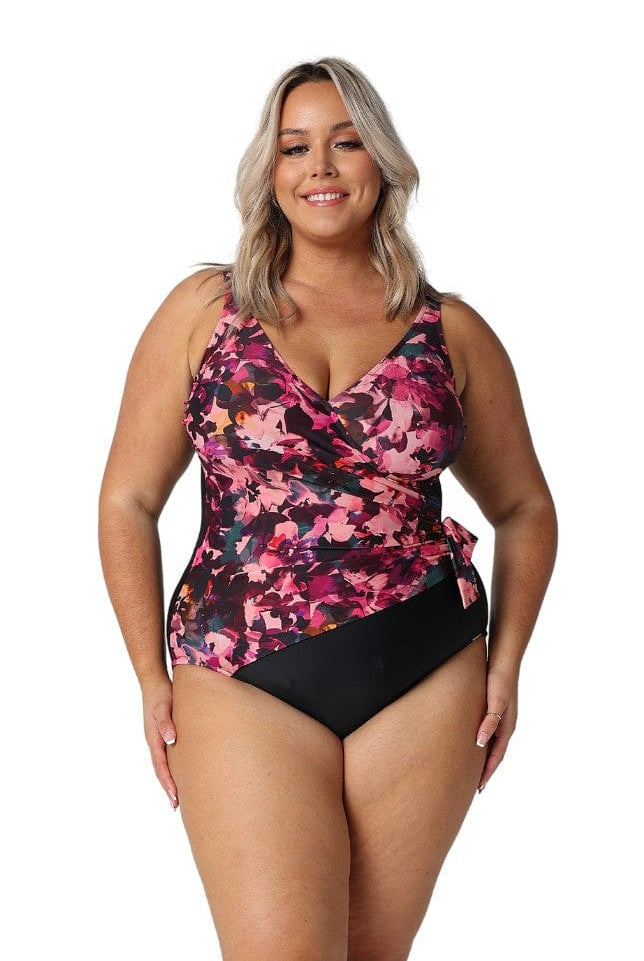 Model wearing pink, plum and black floral crossover detail one piece