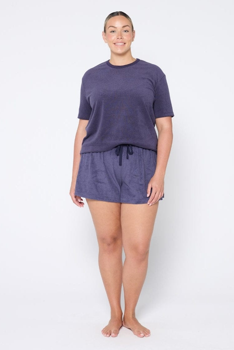 Woman wearing a navy terry towelling
set on a white background