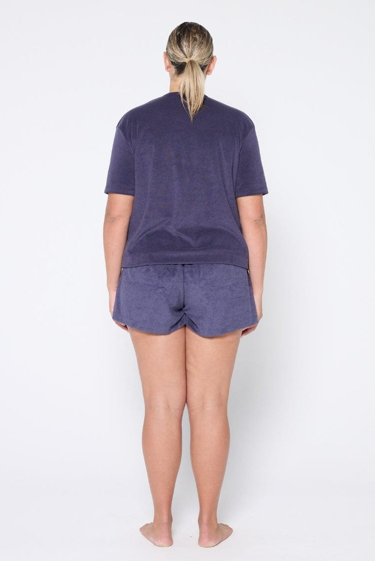 Person wearing a navy t-shirt and shorts set on a white background