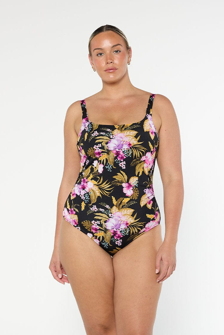 Blonde model wears flattering chlorine resistant one piece swimsuit in gold and pink florals