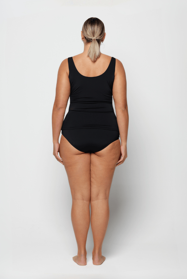 Woman wearing a black swimsuit on a white background