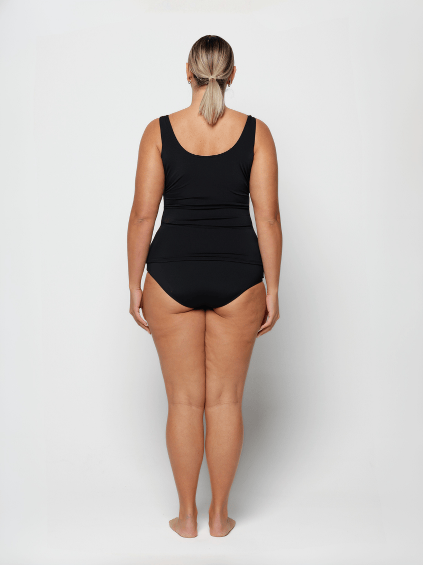 Woman wearing a black swimsuit on a white background