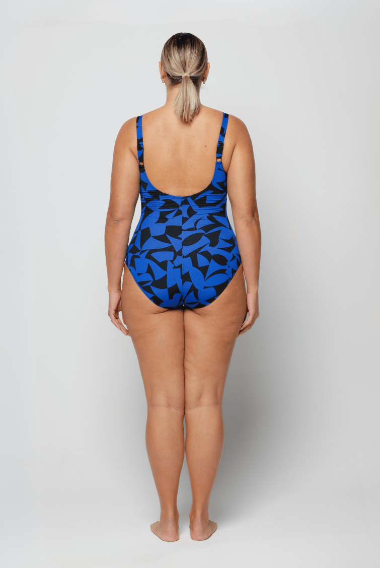 Woman wearing a blue and black patterned swimsuit on a white background