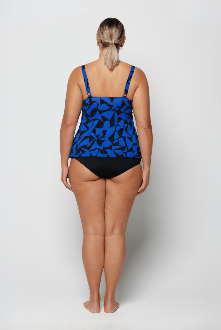 Woman wearing a blue and black patterned tankini on a white background