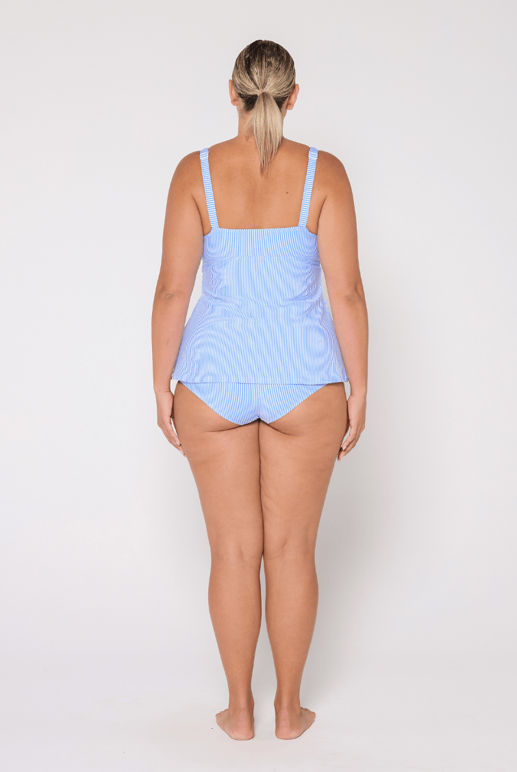 Woman wearing a light blue tankini top on a white background
