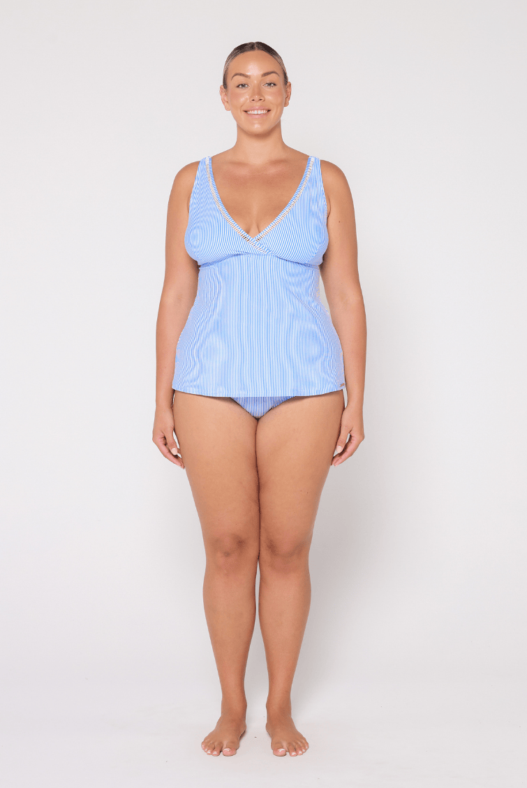 Woman wearing a light blue striped tankini against a white background
