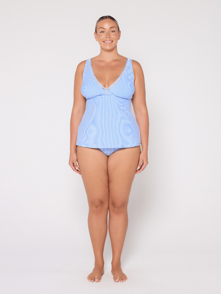 Woman wearing a light blue striped tankini against a white background