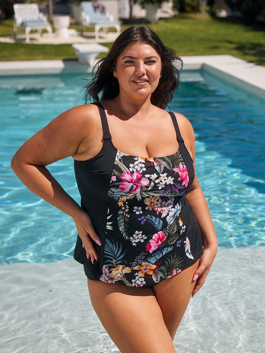 Brunette model wears flattering chlorine resistant tankini top in black floral print