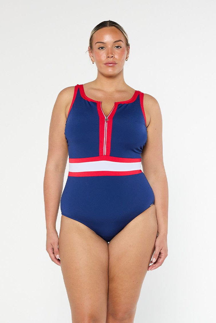 model wearing navy, red and white sporty swimsuit with zip front