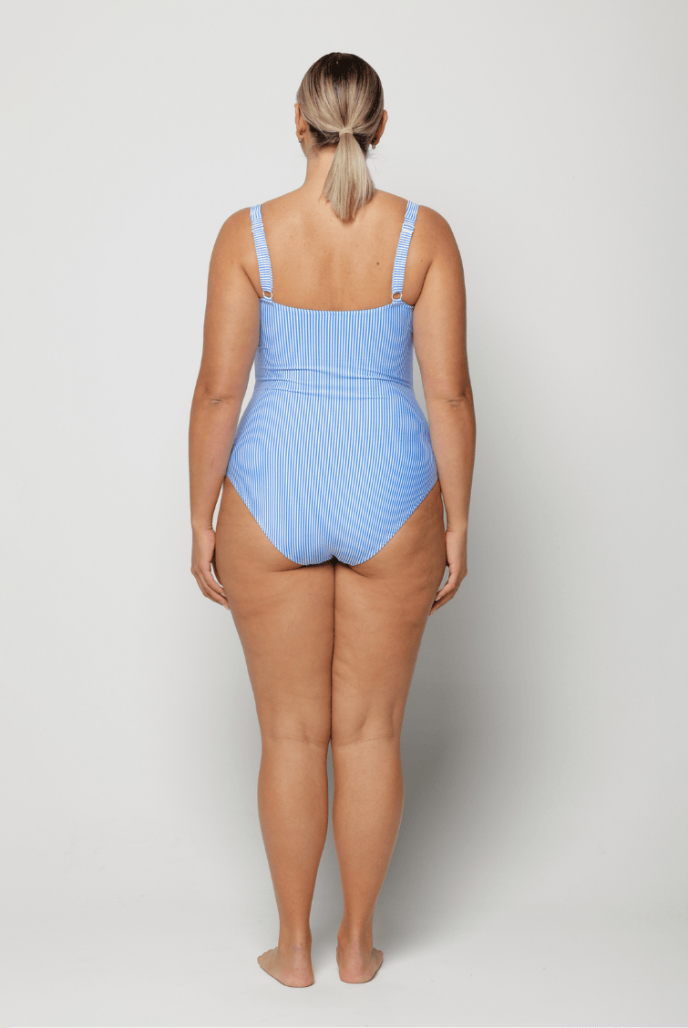 Woman wearing a blue square neck swimsuit on a white background with adjustable straps