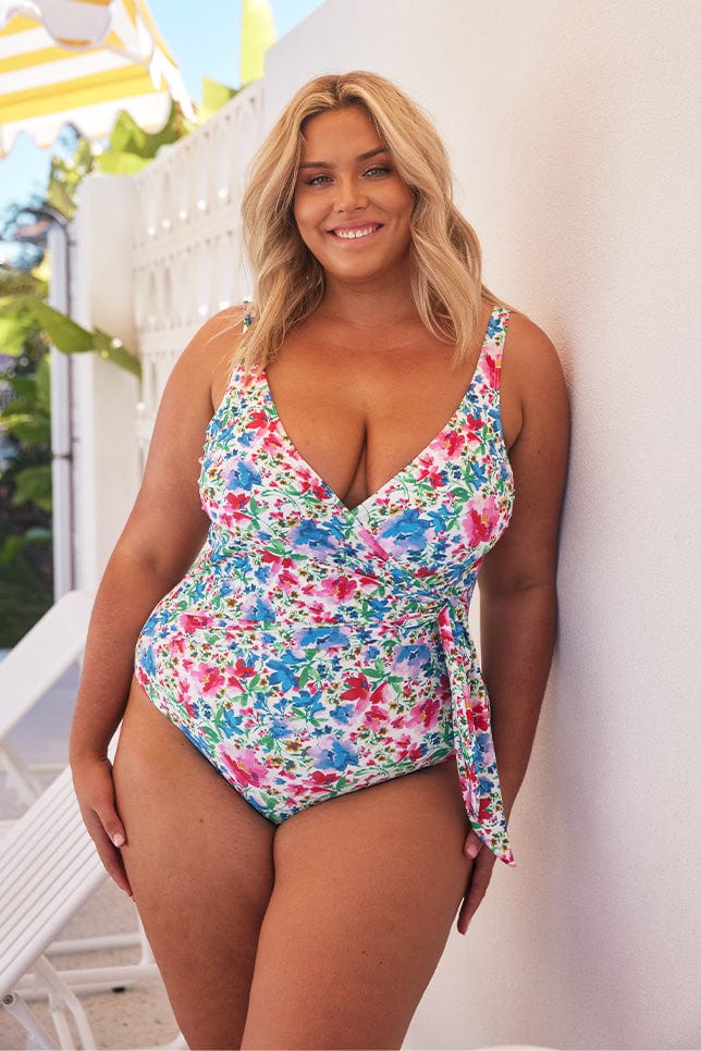 Blonde model wears bright floral waist tie one piece swimsuit