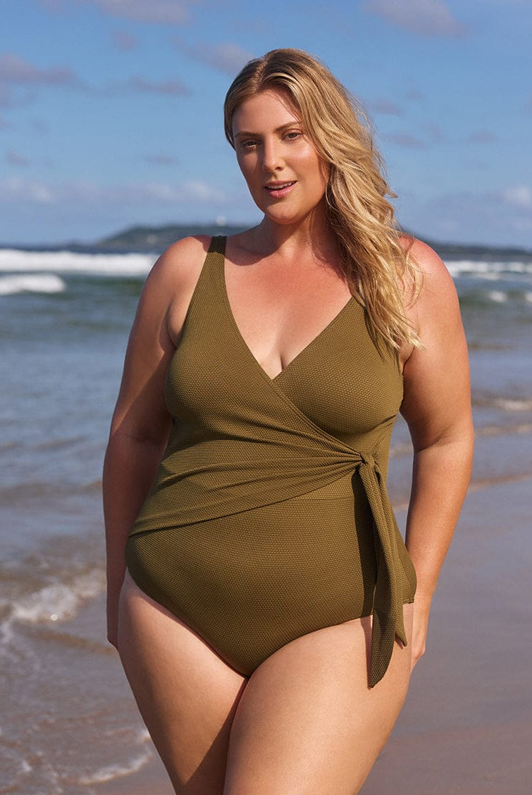 Woman wearing a green swimsuit on a beach