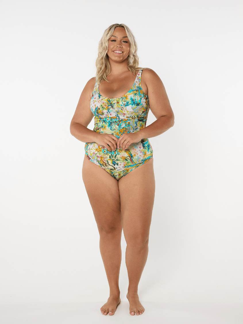Woman wearing a floral one-piece swimsuit on a white background