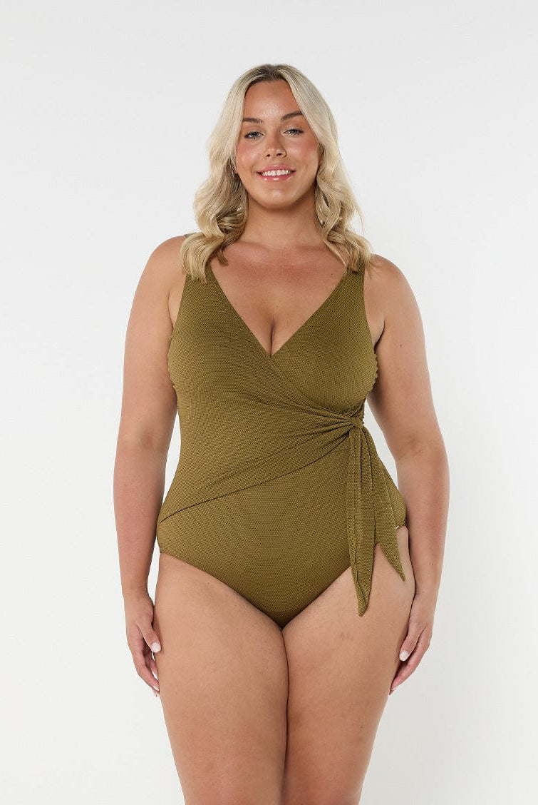 Blonde model wears low v neck one piece with flattering tie side detail in textured honeycomb fabric