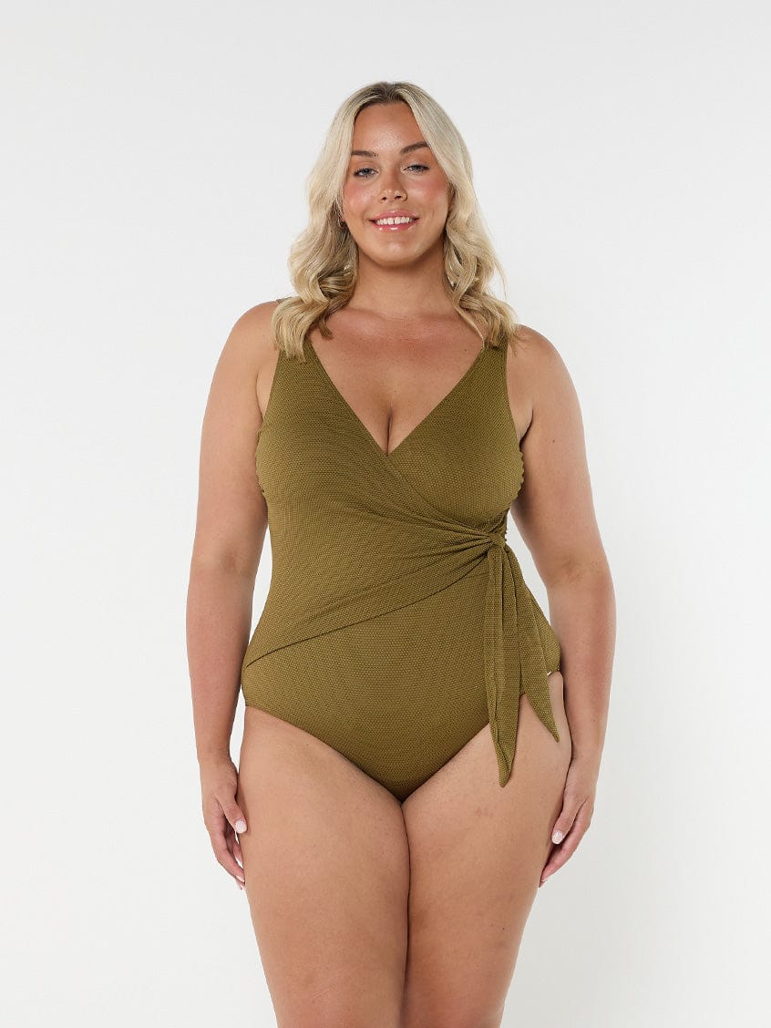 Blonde model wears low v neck one piece with flattering tie side detail in textured honeycomb fabric