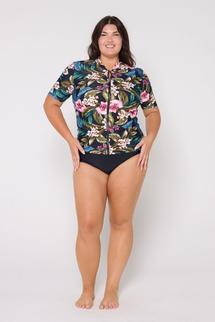 Model in studio wearing a floral short sleeve rash vest with full zip