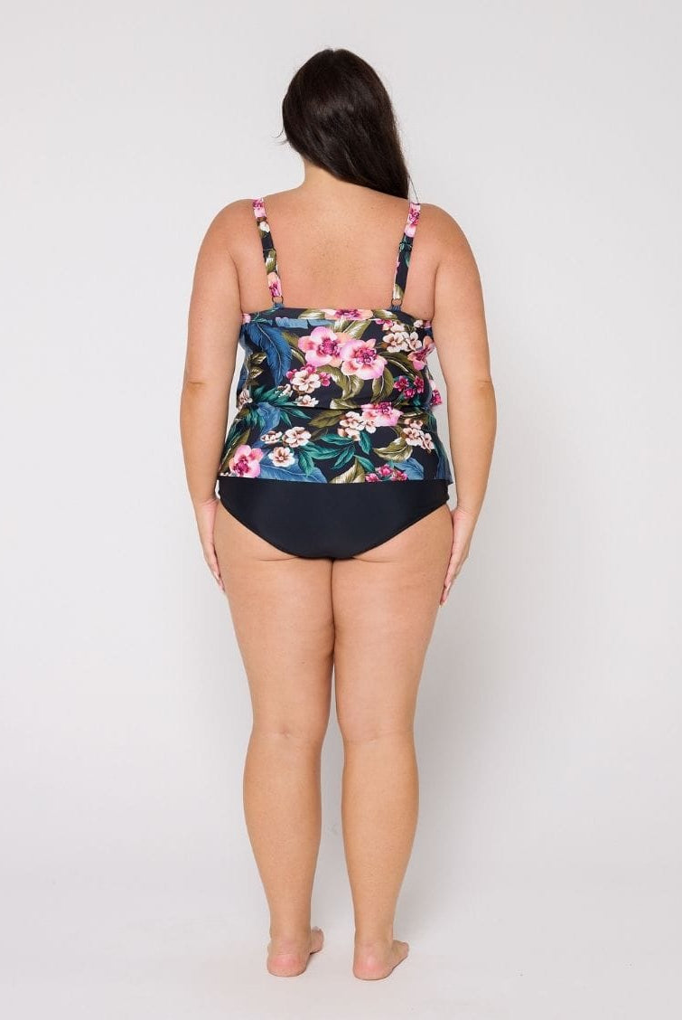 Woman in studio wearing a ruffle tankini top with adjustable straps in floral print